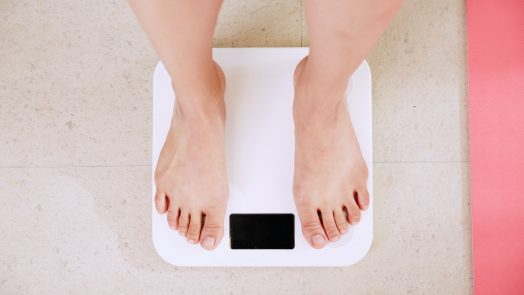 person standing on white digital bathroom scale