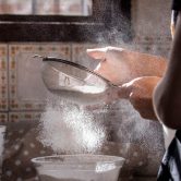 person pouring water on clear glass bowl