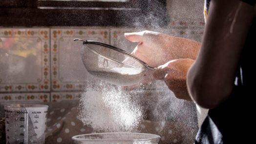 person pouring water on clear glass bowl