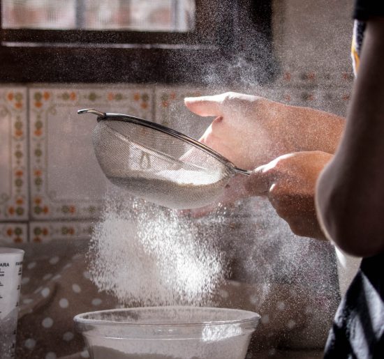 person pouring water on clear glass bowl