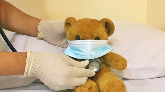 brown bear plush toy on white bed