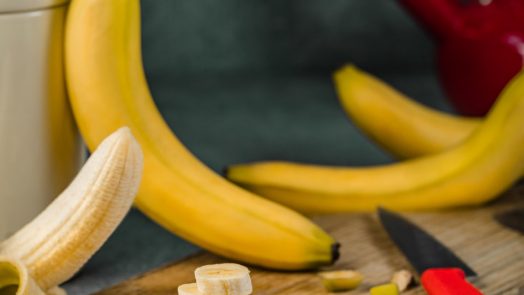 yellow banana fruit on brown wooden chopping board