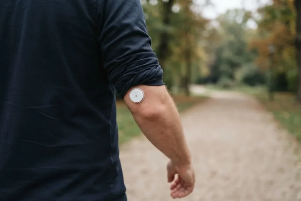 Anonymer Oberarm mit neutralem Glukosesensor bei einem Spaziergang